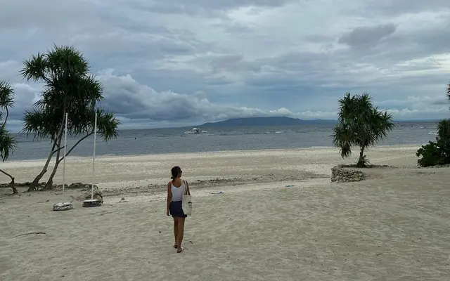 Ann walking on a quiet beach on Bohol, her home island