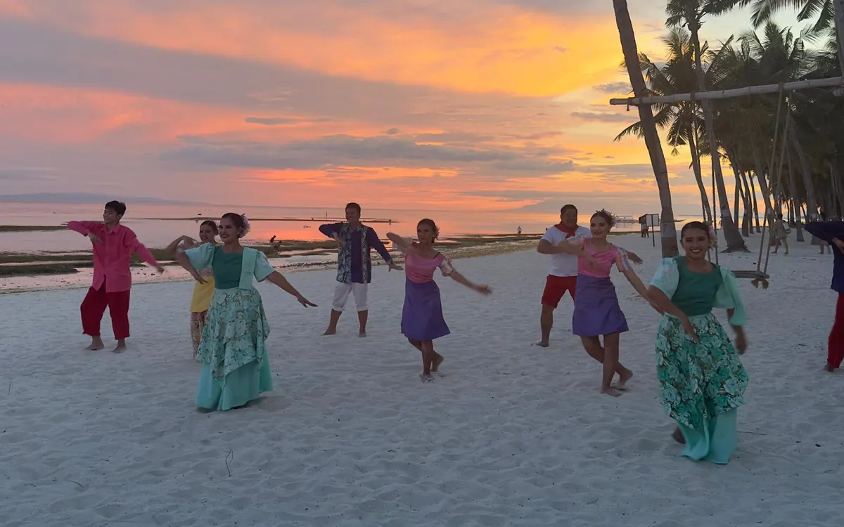 Folk dancers performing on the beach at sunset at a wedding celebration, Bohol